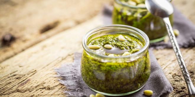 Tomatillo-Sunflower Salsa Verde in glass jars on a rustic wooden table.