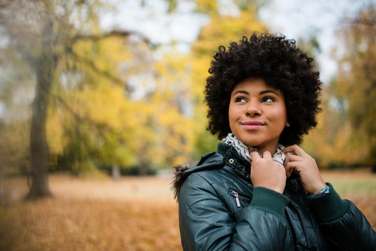 Candid shot of a young woman outdoors in autumn.