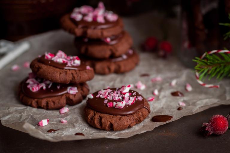 a plate of chocolate cookies with crushed candy canes